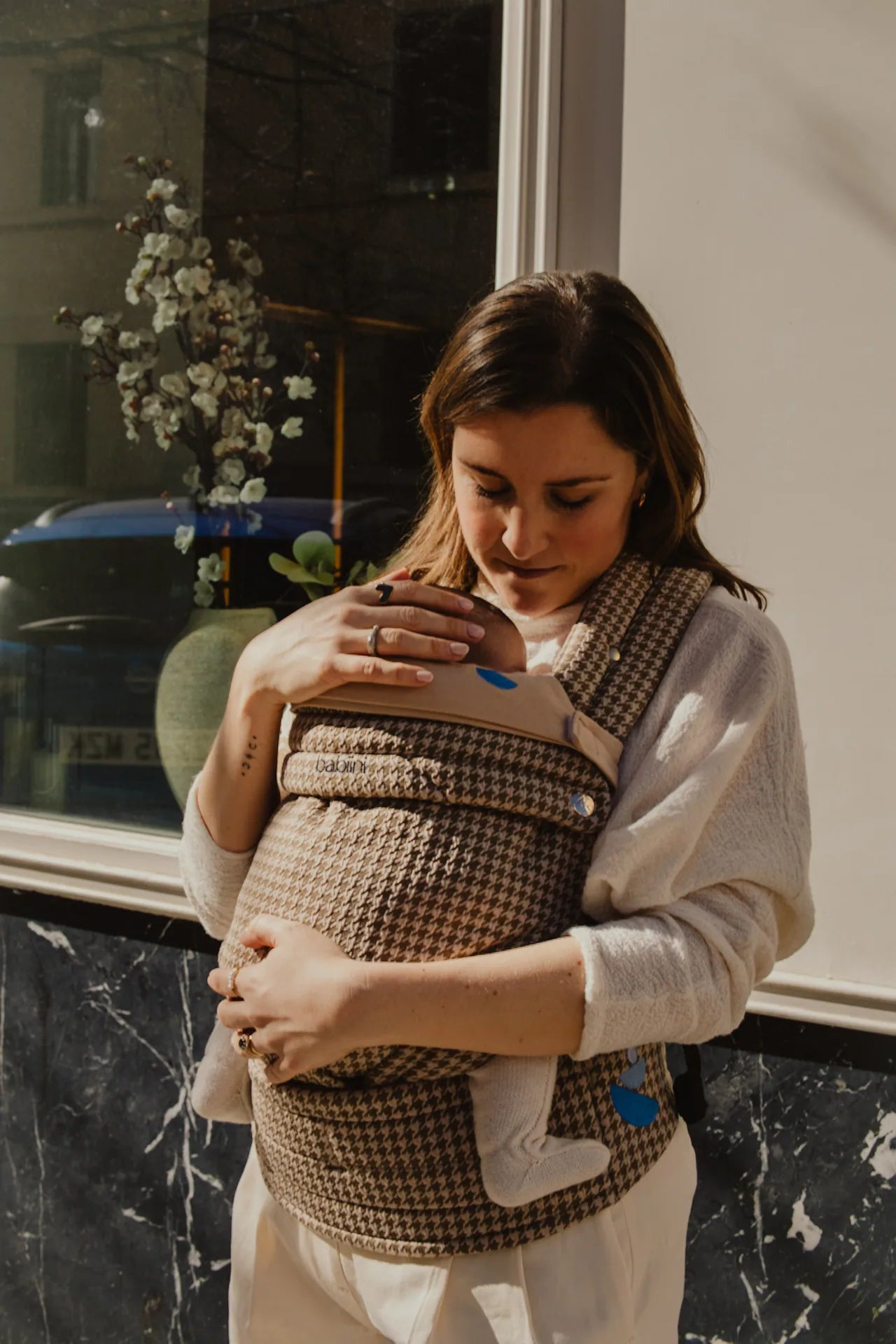 Madre sosteniendo a su bebé en un portabebés