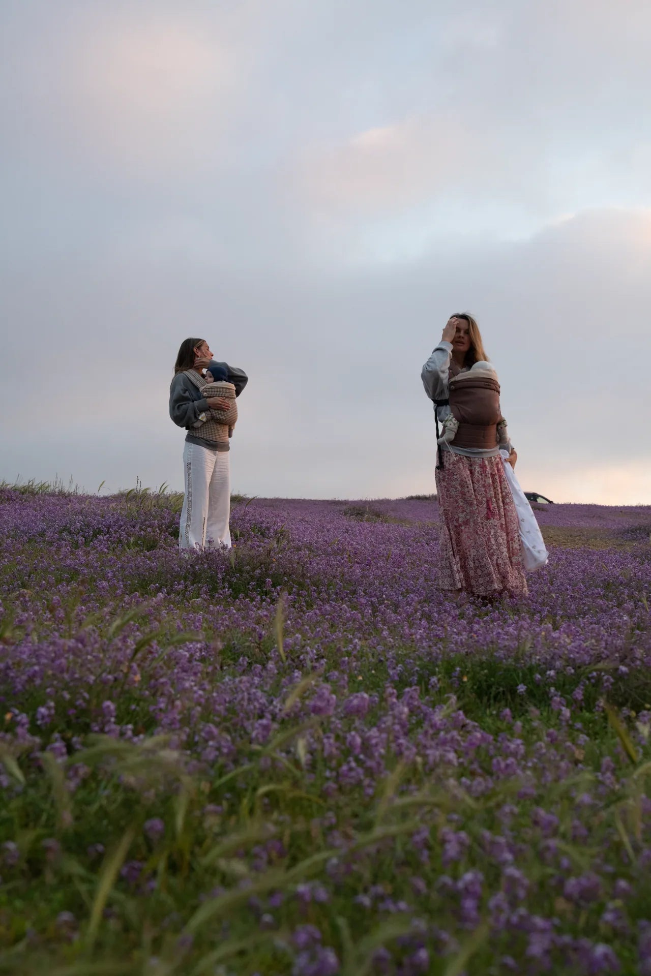 Dos madres con sus bebés en un campo