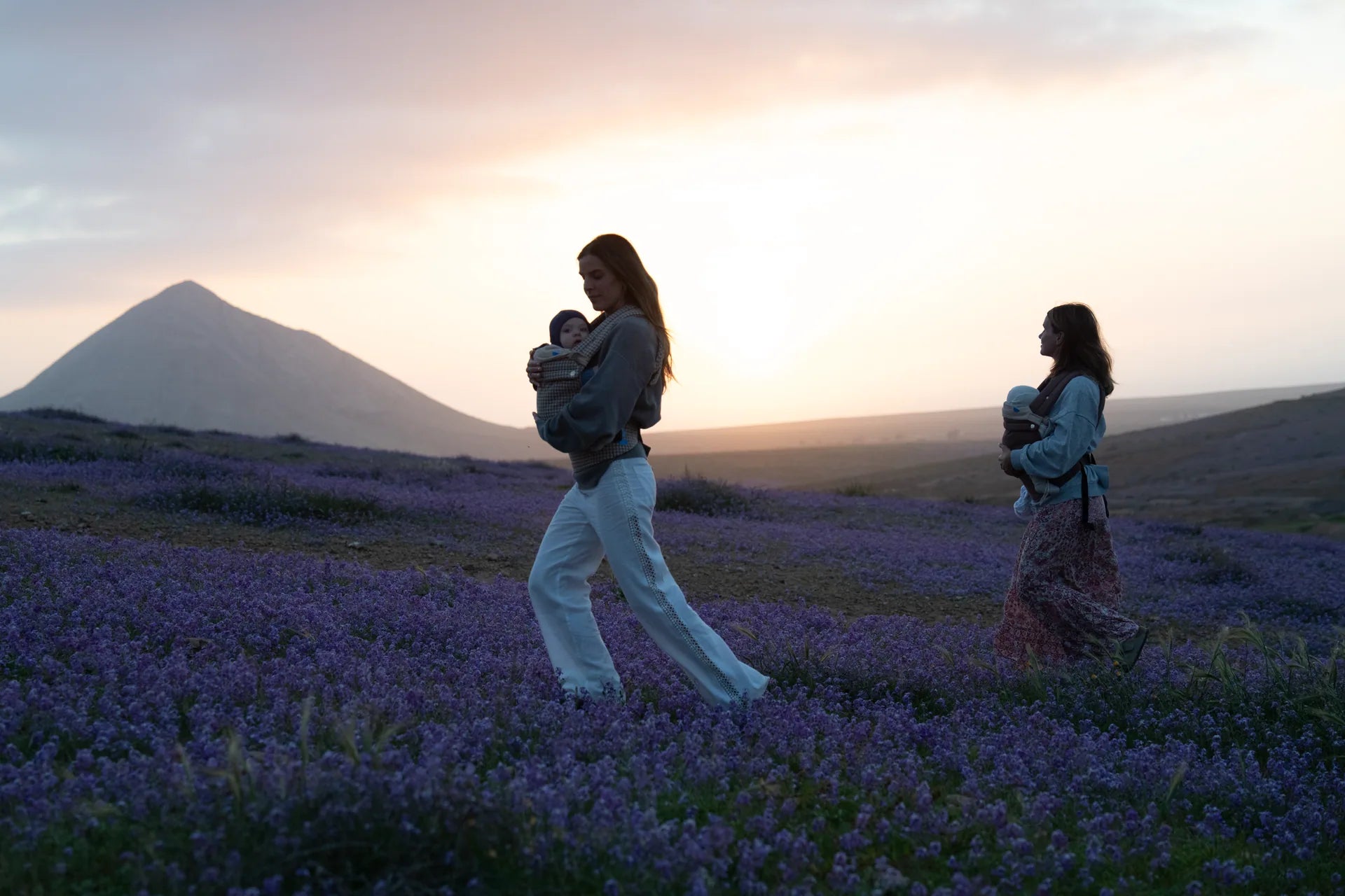 Madre con portabebés al atardecer